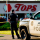A police officer stands guard outside the scene of a shooting at a supermarket, in Buffalo, N.Y., Sunday, May 15, 2022.